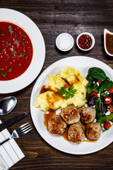Roast meatballs with potatoes and vegetable salad