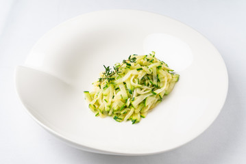 zucchini pasta with thyme on the white plate