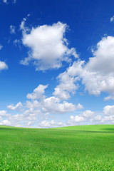 Idyllic view, green hills and blue sky with white clouds