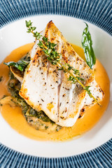 Fried fish fillet. Cod with sauce and herbs