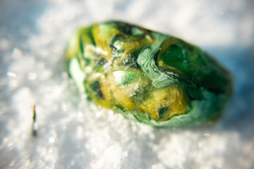 unusual yellow-green handmade soap, macro photo in winter on the snow, malachite stone