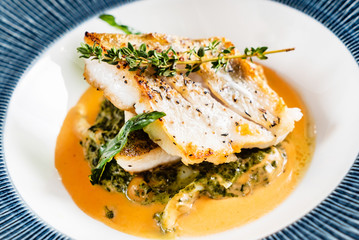 Fried fish fillet. Cod with sauce and herbs
