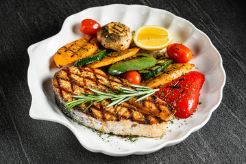 Grilled salmon steak with grilled vegetables and red wine