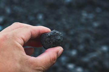 Coal miner in the man hands of coal background. Industrial coals.
