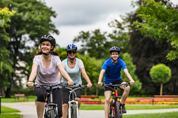 Healthy lifestyle - people riding bicycles in city park