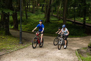 Healthy lifestyle - people riding bicycles in city park