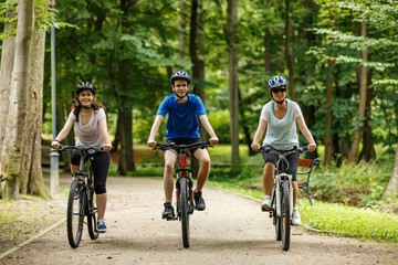 Healthy lifestyle - people riding bicycles in city park