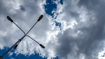 silhouette of a street lamp against a sunny blue sky