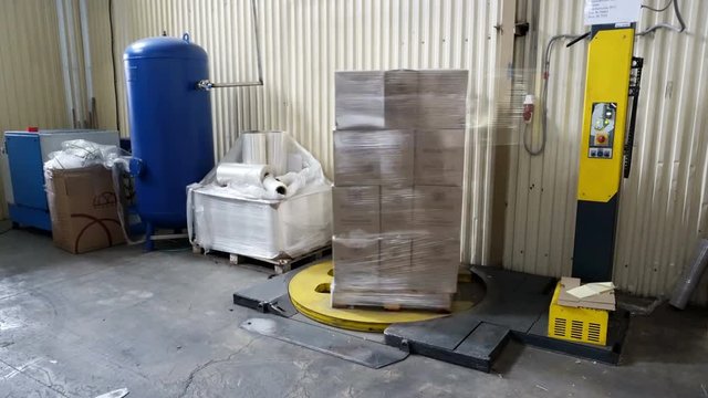 Packing of boxes with wine on a pallet in the polymeric film