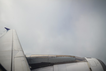 Clouds and sky as seen through window of an aircraft. Exotic view from the window of an airplane flying above the clouds. Beautiful view above the earth at the clouds below.