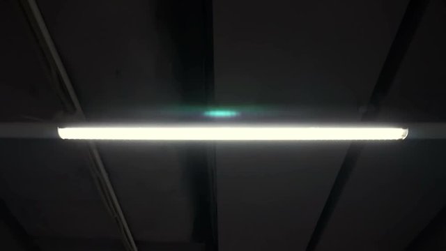 Movement at the bunker in underground corridor with fluorescent lamps on the ceiling