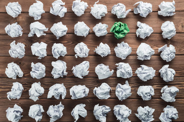 Concept of creativity and inspiration presented by many white paperballs and one color