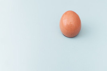 A brown sparkling egg on blue background. Easter egg