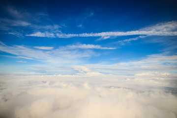 Clouds and sky as seen through window of an aircraft. Exotic view from the window of an airplane flying above the clouds. Beautiful view above the earth at the clouds below.