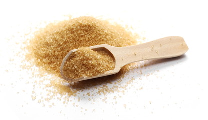 Brown cane sugar pile with wooden spoon isolated on white background and texture