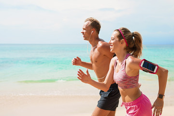 Man and woman running on beach together
