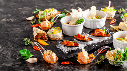European cuisine. appetizer for wine on a black background. Pate, mini salad, canape, sea products, salmon and mussels in tomato sauce. Top view, copy space