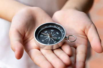 Compass in kid hand, giving direction concept © sundaemorning