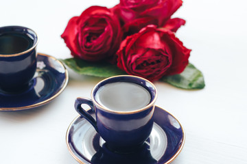 Obraz premium Two coffee mugs on a table decorated with roses