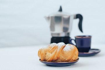 Brewed cake, coffee and coffee maker on the table.