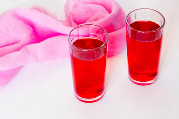 Fruit and berry red juice in glasses on a white background. Fresh and cold summer drink.
