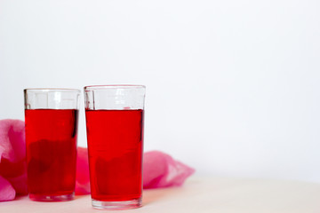 Fruit and berry red juice in glasses on a white background. Fresh and cold summer drink.