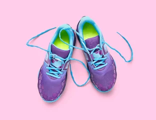 Foto op Plexiglas Top view of blue and purple trainers isolated on a pink background. © Duncan Andison