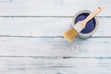 Top of view paint can with blue color and brush on table