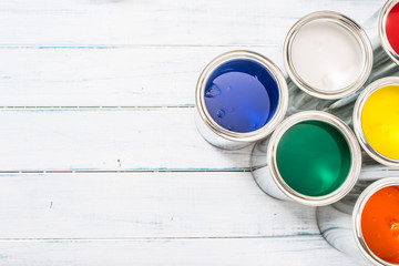 Top of view full of multicolored paint cans on table.