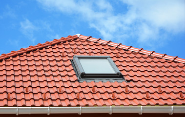 Attic skylight window on modern house roof top.