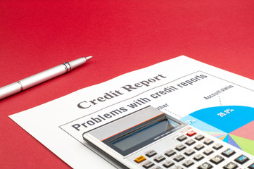 Credit report on the red table and a pen.