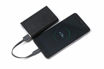 smartphone is charging from the black battery power bank isolated on white background