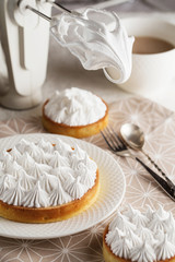Obraz na płótnie Canvas Beautiful freshly made white lemon meringue tart on plate.