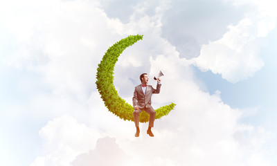 Businessman or manager in blue day sky announcing something in loudspeaker