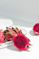 Fresh organic red dragon fruits on a white background, creative healthy food concept