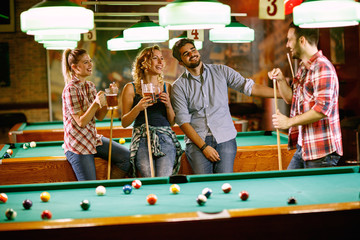 fun with friends on billiard games in bar.