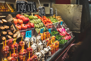 Beautiful fruits in European fair in ready-to-eat glasses. Healthy food for sale in La Boquería market in Barcelona, Spain