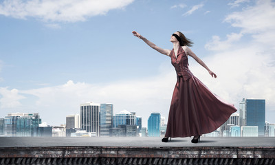 Obraz premium Blind woman in long red dress at top of building. Mixed media