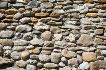 Old textured stone wall of large cobblestones.
