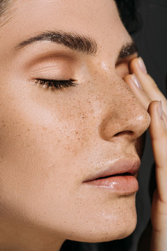 close up of beautiful tender woman with freckles on face isolated on grey