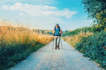 man hiking outdoor in a beautiful road in the fields