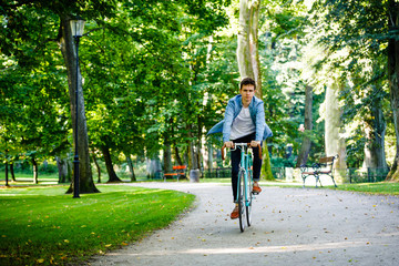 Young man biking in city park