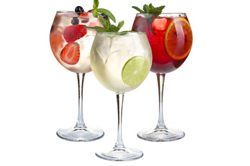 Alcoholic and non-alcoholic cocktails with mint, fruits and berries on a white background. Three light cocktails in glass goblets.