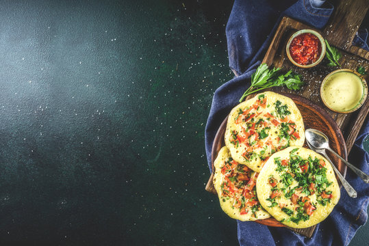 Indian traditional food recipes, Uttapam oats or semolina pancakes with fresh vegetables and herbs, dark blue background copy space top view