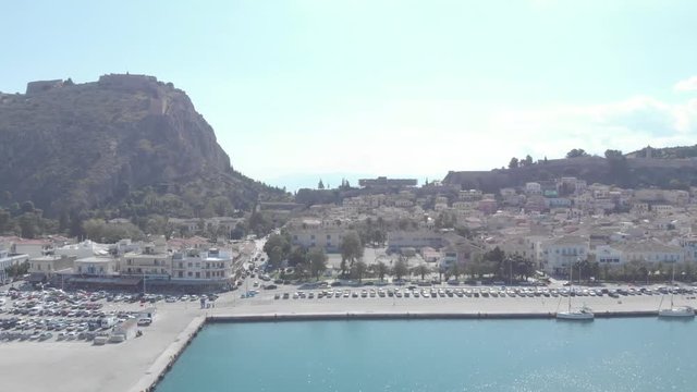 Panning from right to left above the city of Nafplio in Greece. Showing the urban setting while the hill in which the Palamidi Castle stands in the background. Sunny weather. Flat profile but also ava