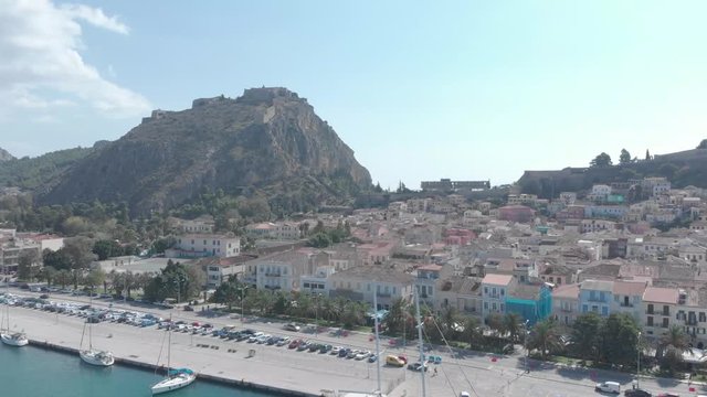 Panning from right to left above the city of Nafplio in Greece. Showing the urban setting while the hill in which the Palamidi Castle stands in the background. Sunny weather. Flat profile but also ava