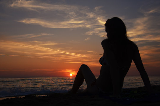 Beautiful woman on the beach at sunset. Woman enjoy on the beach in Greece