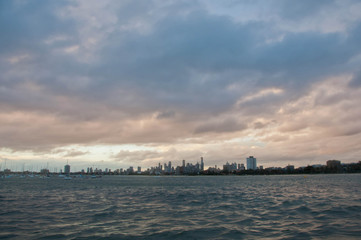 Wide angle evening scene of skyscrapers horizon with ocean and tall office and residential towers in Melbourne Australia