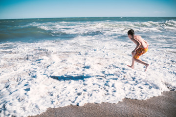 boy on the beach vacation travel discover waves coast sea ocean