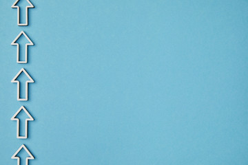 top view of vertical row white arrows on blue background